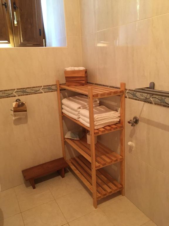 baño con una pila de toallas en un estante en O Fogar do Monte, en Sober