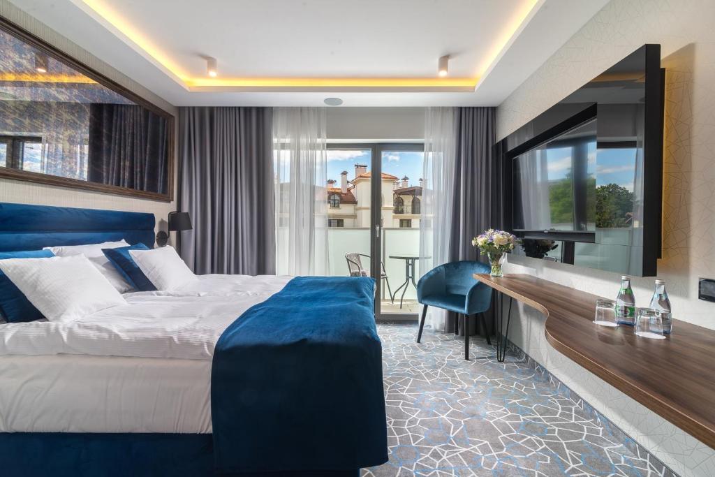 een hotelkamer met een groot bed en een bureau bij Love Sopot Residence in Sopot