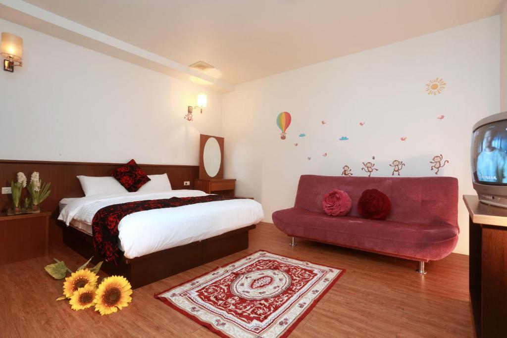 1 dormitorio con 1 cama y 1 sofá rojo en Jia Ying Beach Resort B&B en Toucheng