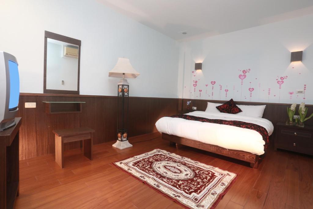 a bedroom with a bed and a mirror and a tv at Jia Ying Beach Resort B&amp;B in Toucheng