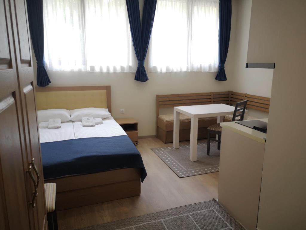 a bedroom with a bed and a table with a desk at Apartments&Camping ZIP in Kremna