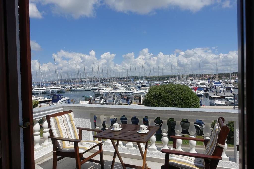 einen Balkon mit einem Tisch und Stühlen sowie einen Yachthafen in der Unterkunft Room Novakovic in Biograd na Moru