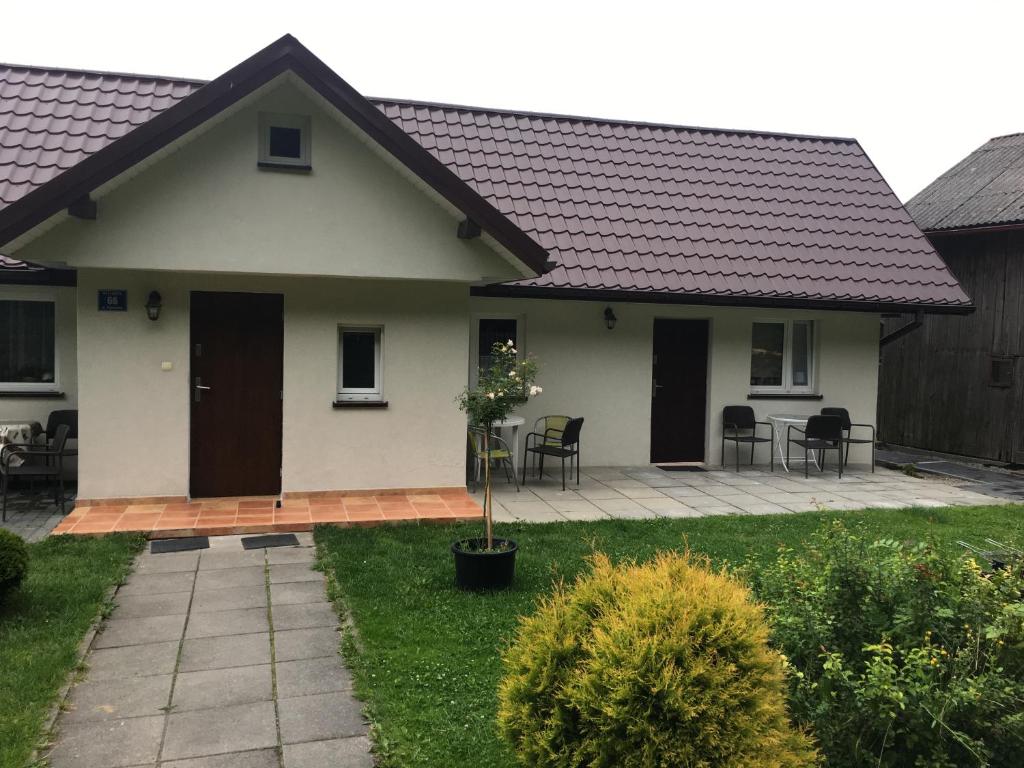 a white house with a patio and table and chairs at Pokoje Gościnne Ojcowska Kraina Pieskowa Skała Ojców in Pieskowa Skała