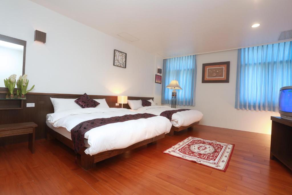 a bedroom with two beds and a flat screen tv at Jia Ying Beach Resort B&amp;B in Toucheng