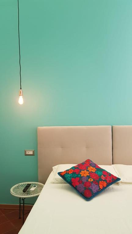 a bed with a colorful pillow sitting on top of it at La Siesta in La Maddalena