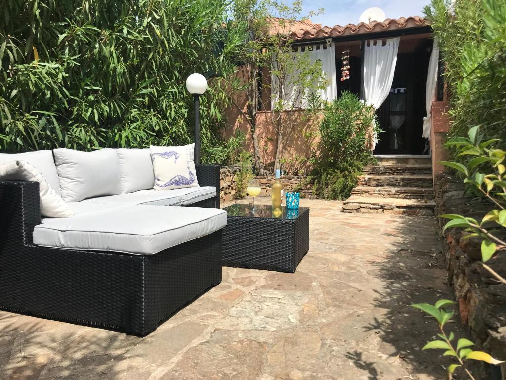 patio con divano bianco e tavolo di Baia Sant'Anna a Budoni