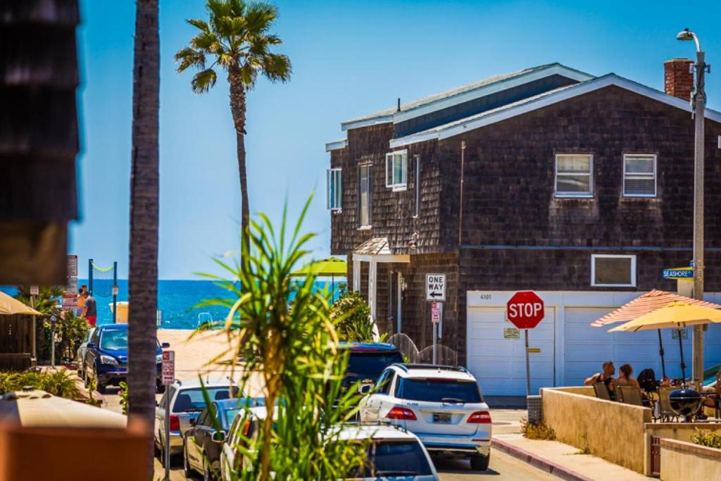 una señal de stop frente a un edificio y una playa en Modern Newport Beach Condos en Newport Beach