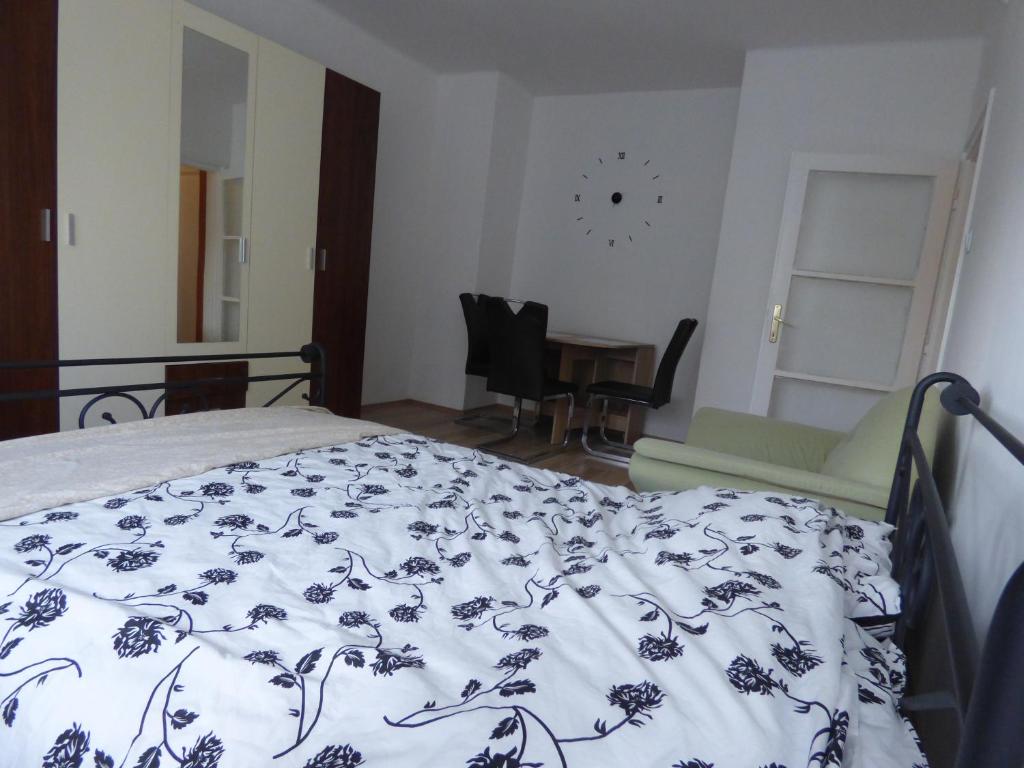 ein Schlafzimmer mit einem Bett mit einer blauen und weißen Decke in der Unterkunft Bega Apartman in Barcs