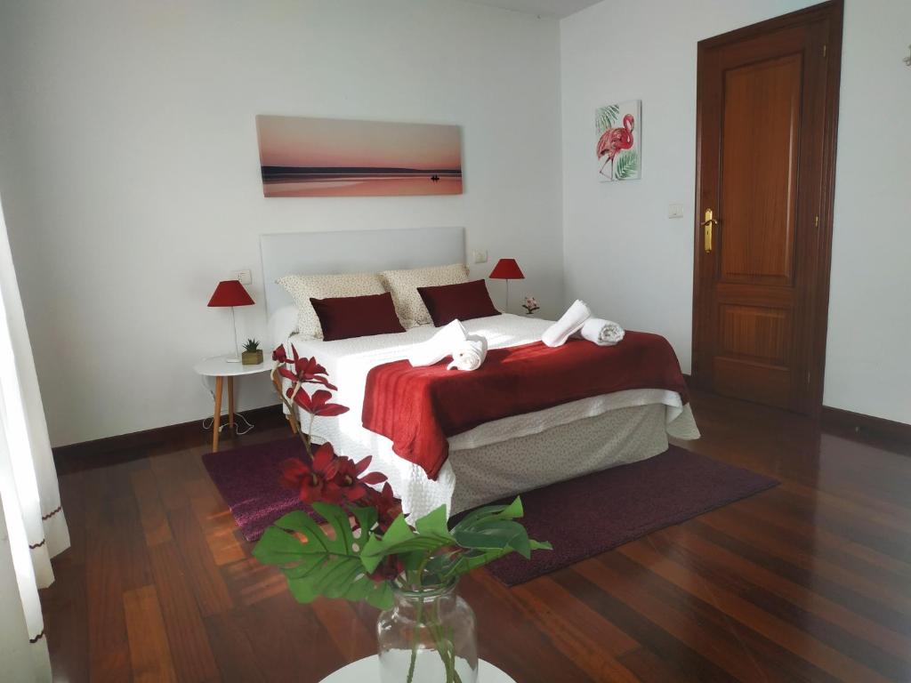 a bedroom with a bed with a red and white blanket at Apartamento en Casa Amelia 1ªP in Padrón