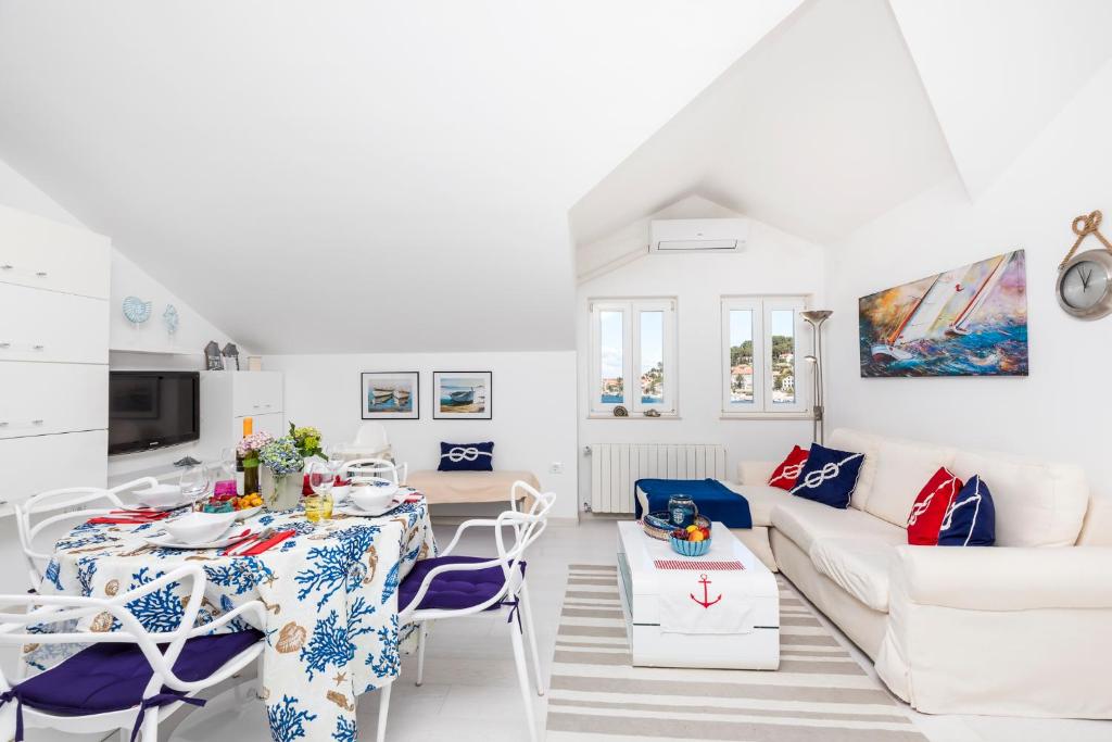 a white living room with a table and chairs at Apartments Priko 63 in Mali Lošinj