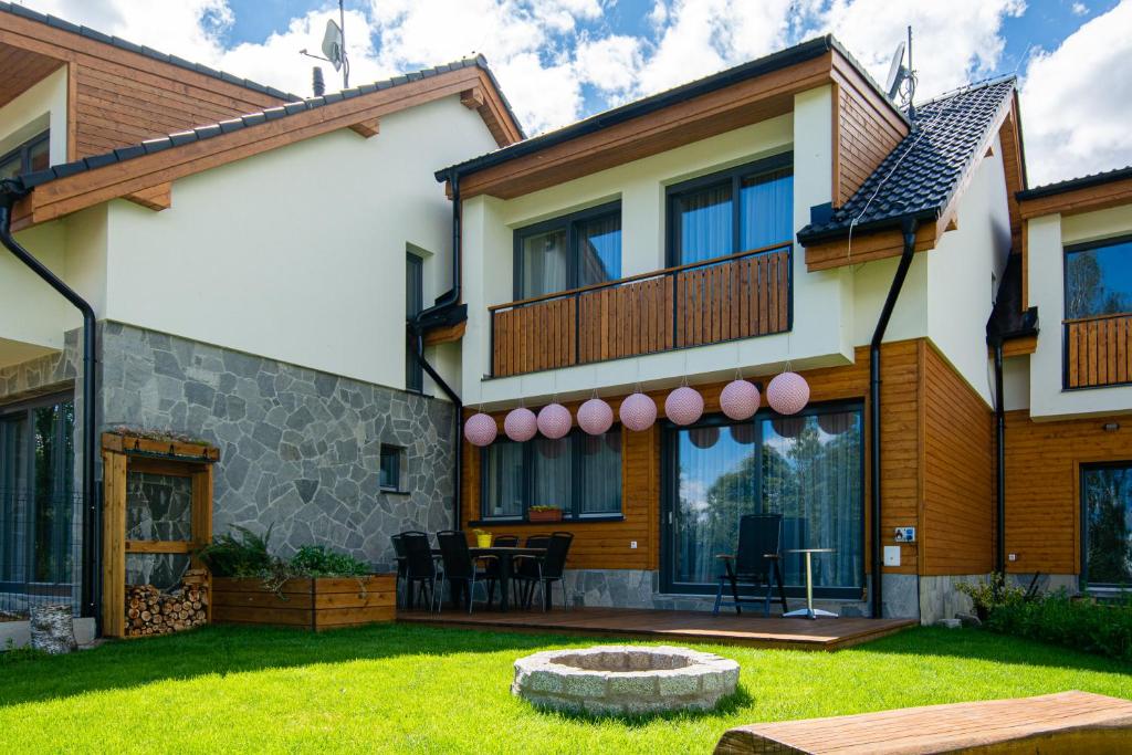 a house with a balcony and a yard at VILA DOMOVINA in Vysoke Tatry - Tatranska Lomnica.