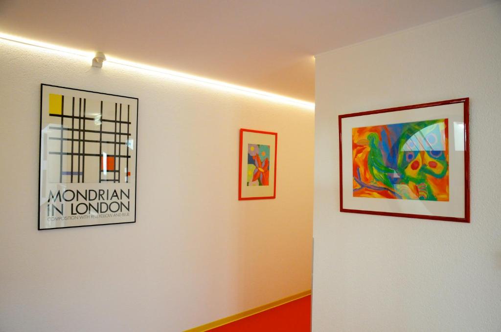 a hallway with paintings on the walls of a room at Domus Hotel in Luxembourg