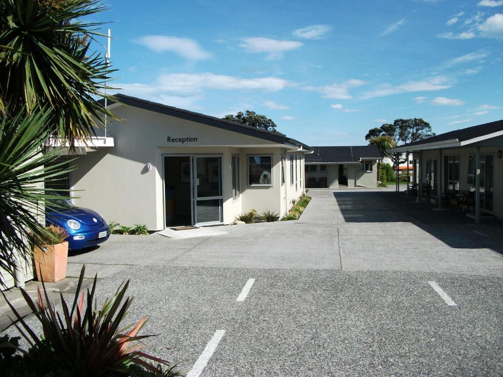a building with a car parked in a parking lot at Scenicland Motels in Greymouth