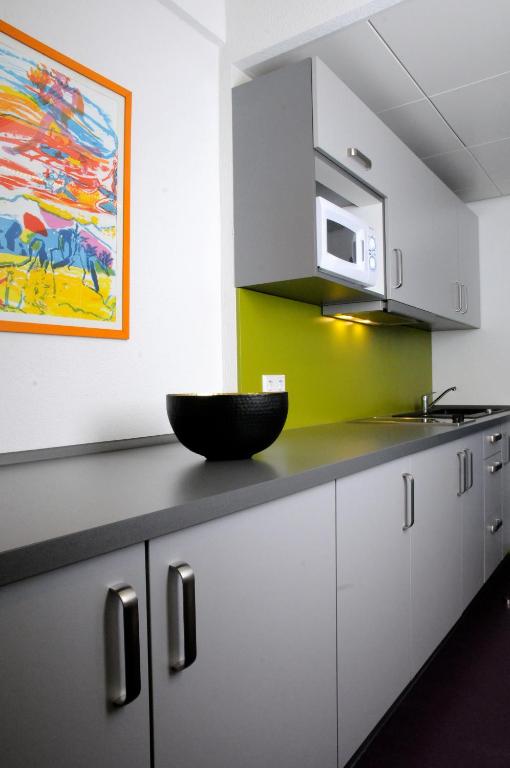a kitchen with white cabinets and a bowl on the counter at Domus Hotel in Luxembourg