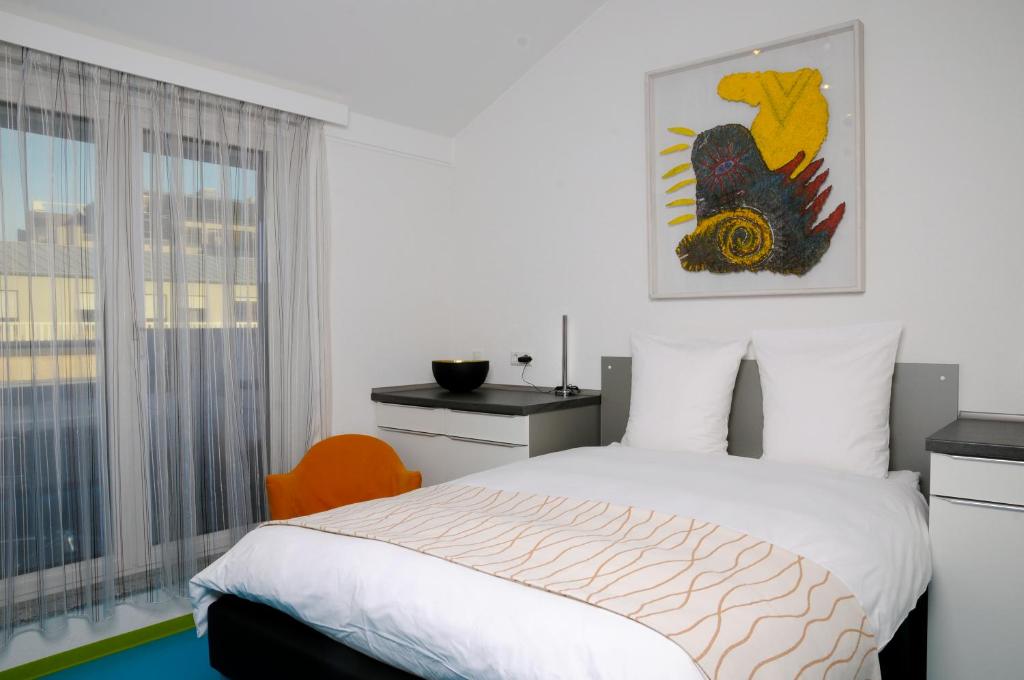 a bedroom with a bed and a window at Domus Hotel in Luxembourg
