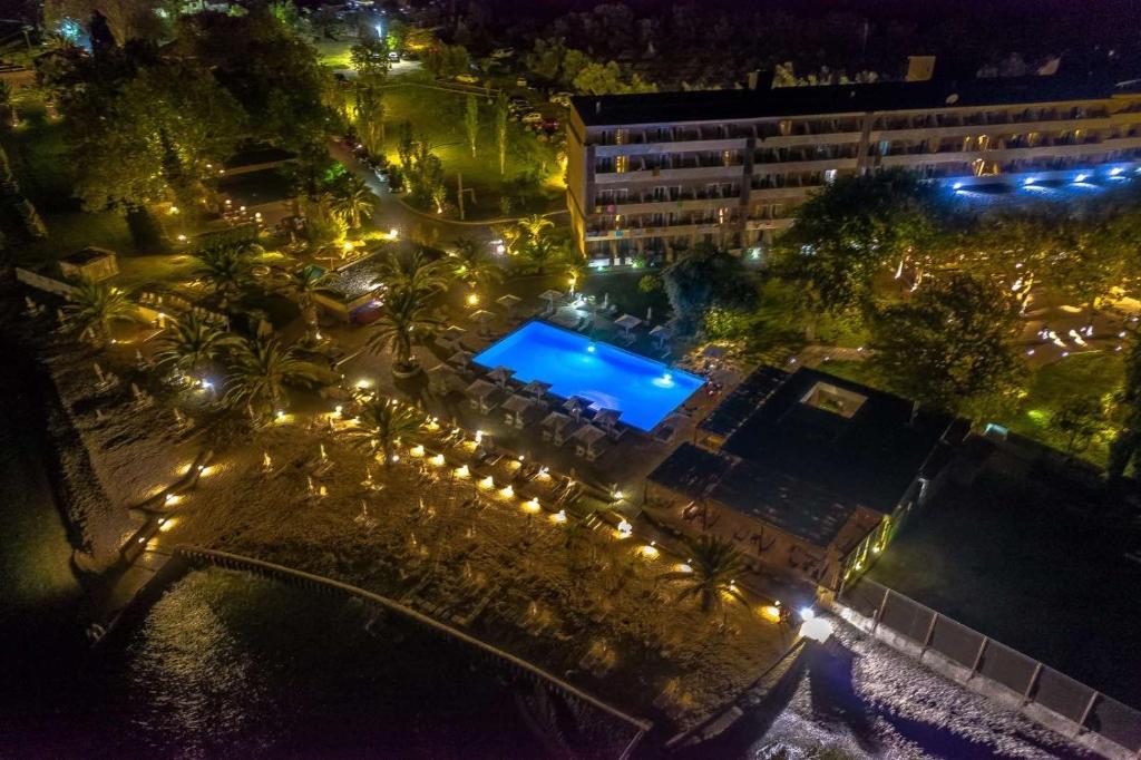 an overhead view of a pool at night with lights at Long Beach Hotel & Resort in Lóngos