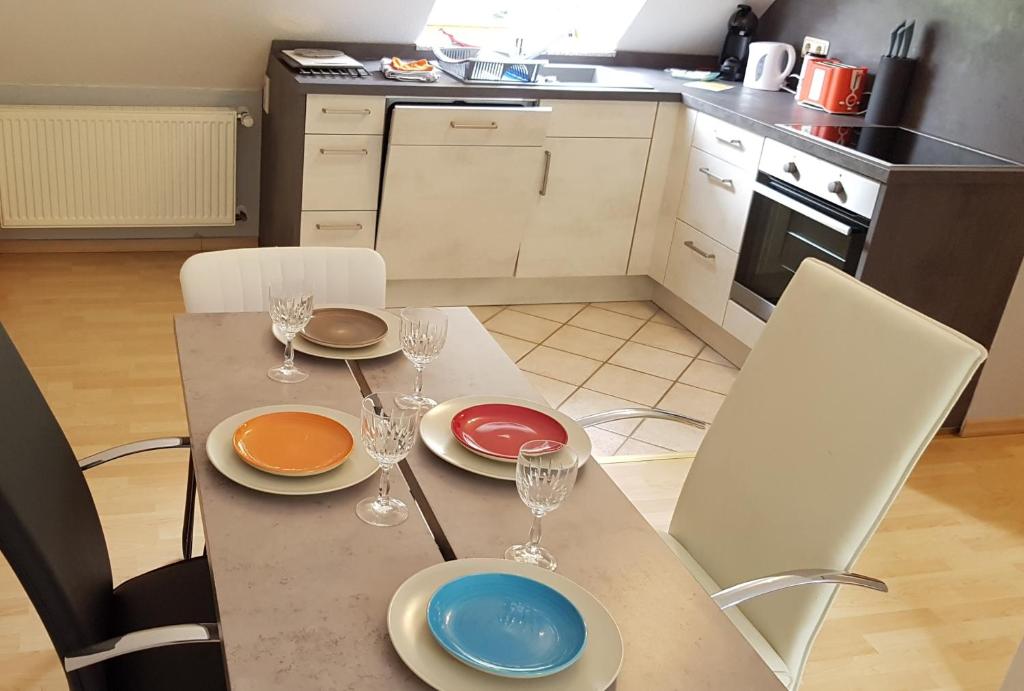 eine Küche mit einem Tisch mit Tellern und Weingläsern in der Unterkunft Iris 2-3 Personen - Ferienwohnungen Wagner & Gaul Falkenauel in Falkenauel