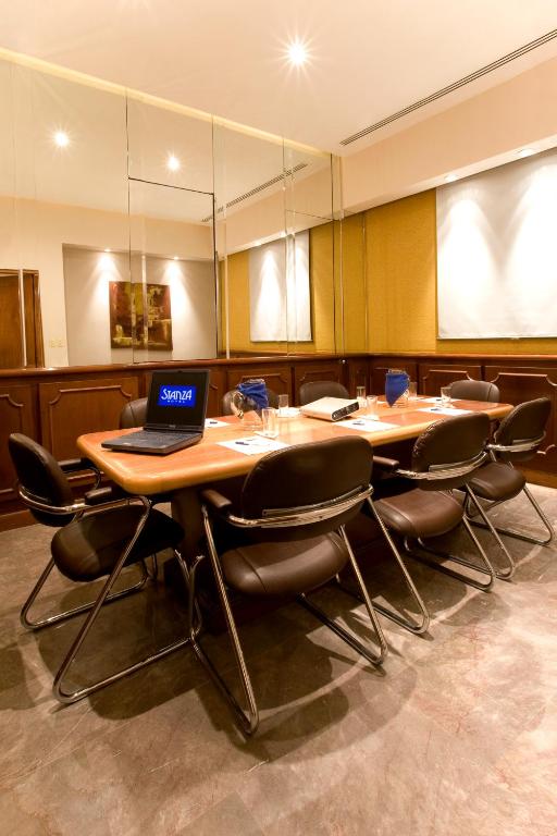 A private conference room with a meeting table, laptop, and several chairs.