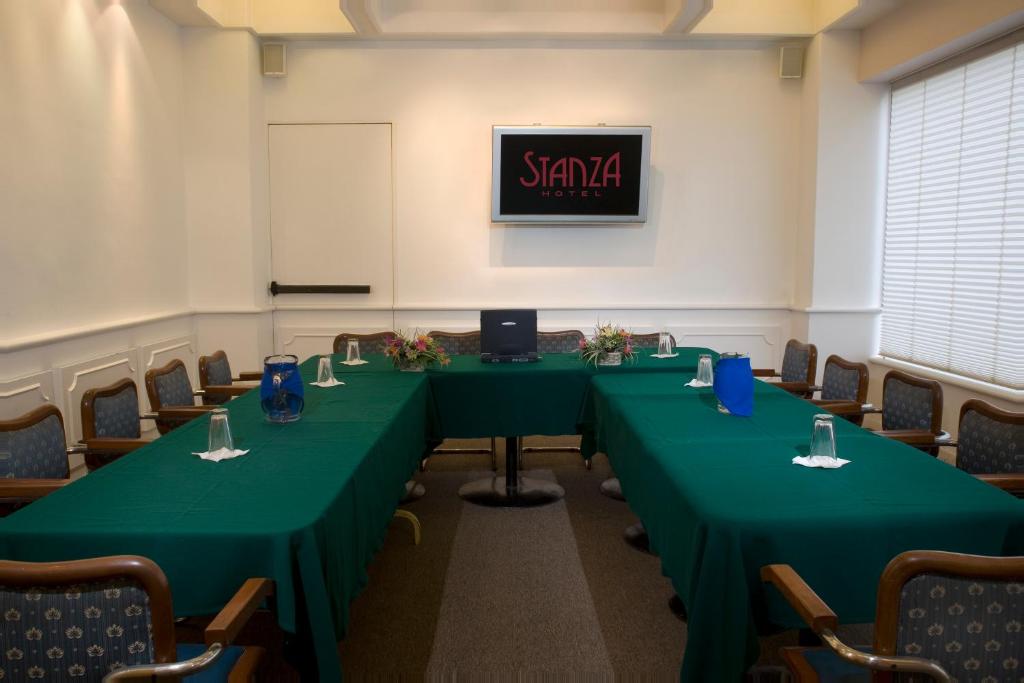 A boardroom-style meeting room set with green-clothed tables.