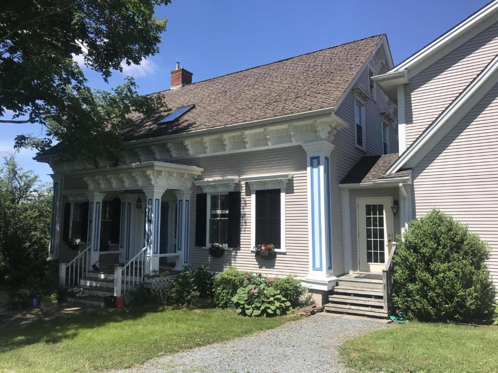 Cette maison blanche dispose d'une véranda et d'une fenêtre. dans l'établissement Cresthaven By the Sea, à South Maitland