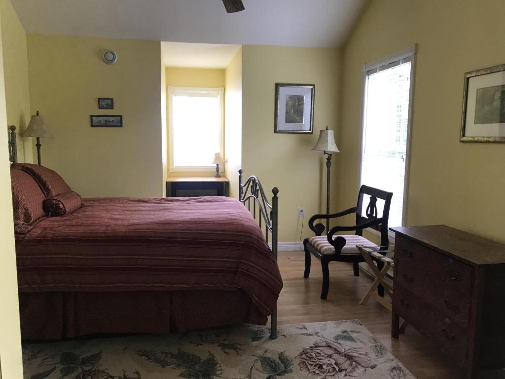 una camera da letto con un letto, una sedia e una finestra di Cresthaven By the Sea a South Maitland