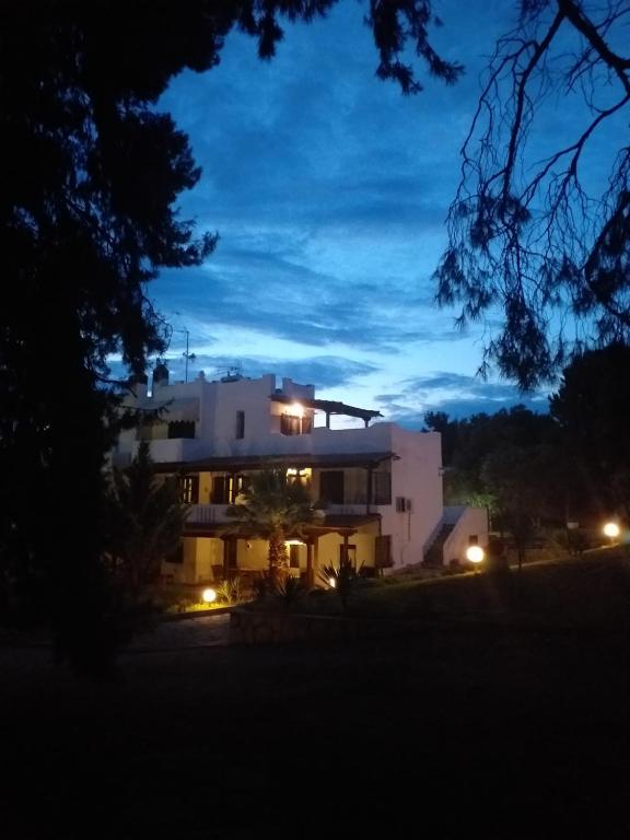 ニキティにあるCortessa Apartmentsの夜間照明付きの大きな白い家