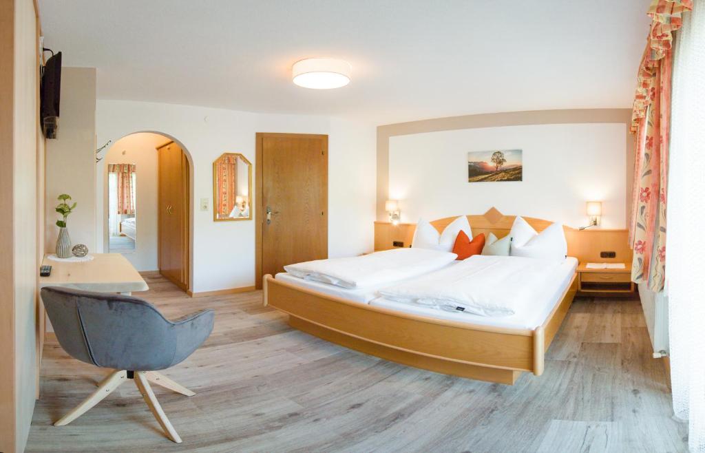 1 dormitorio con cama, escritorio y silla en Haus Martina en Tux