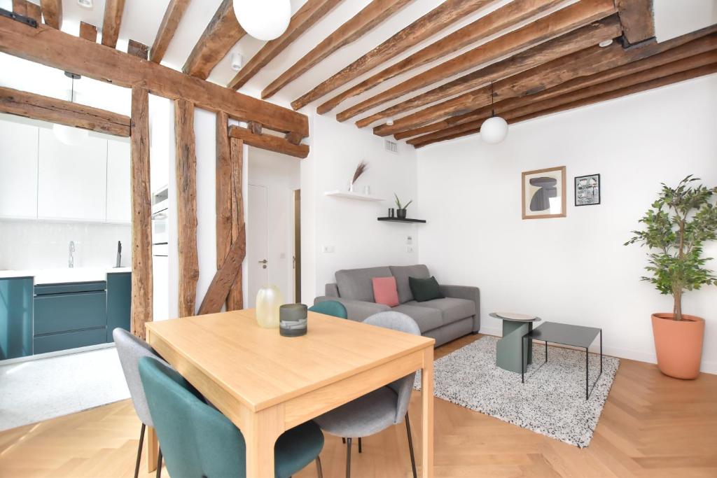 un salon avec une table en bois et un canapé dans l'établissement Authentic apartment 1BR-4P République - Le Marais, à Paris