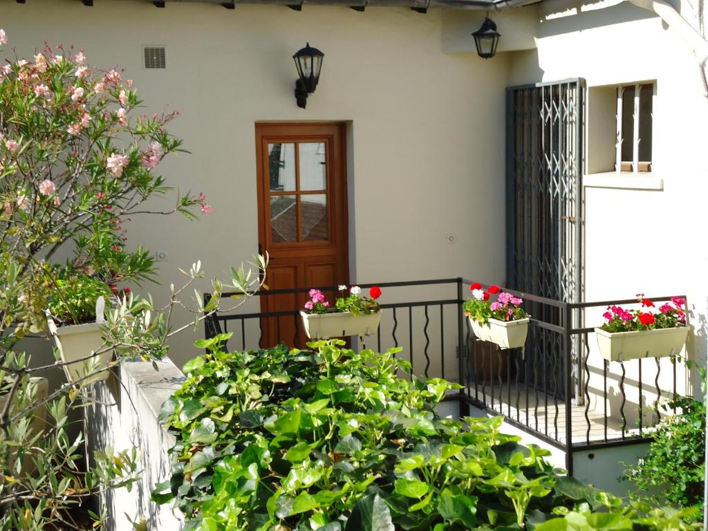 ein Haus mit Topfpflanzen auf einem Balkon in der Unterkunft City Cottage le Montreuillois in Montreuil