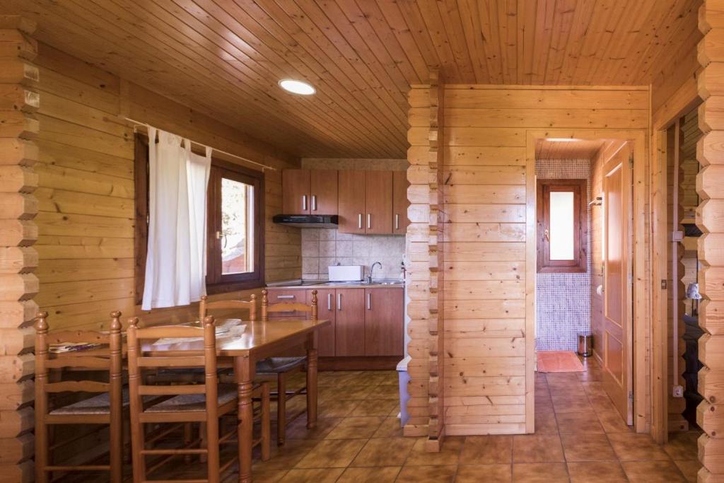 una cocina con mesa y sillas en una cabaña en Camping Globo Barcelona, en Canet de Mar