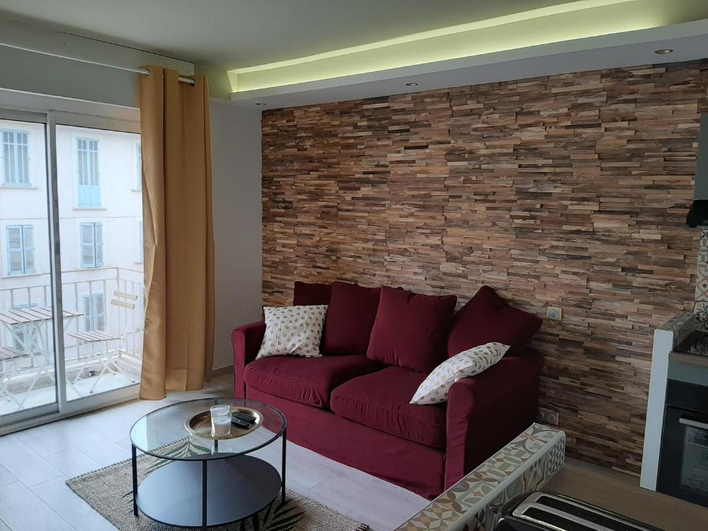 - un salon avec un canapé rouge et un mur en briques dans l'établissement Studio Suquet balcony 1 min beach, 10 min Palais & Croisette Works, à Cannes