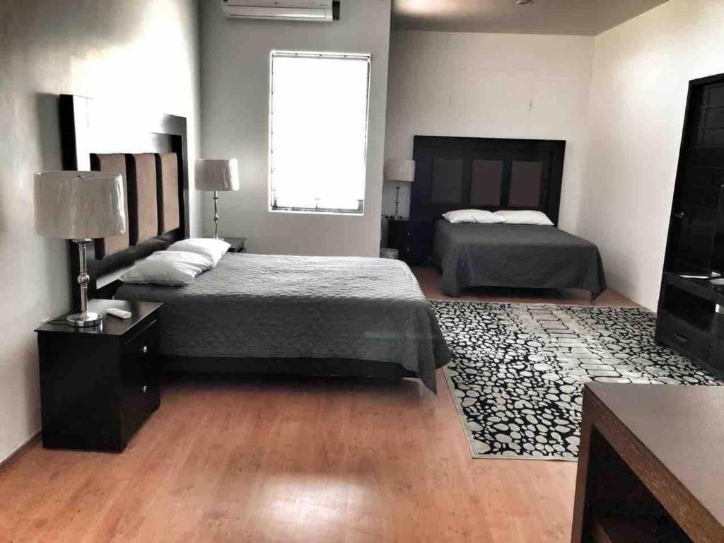 Habitación grande con 2 camas y TV. en 10 Large suite for 4 people, en Torreón