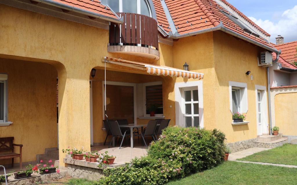 Cette maison dispose d'une terrasse avec une table et des chaises. dans l'établissement B6 Apartman, à Veszprém