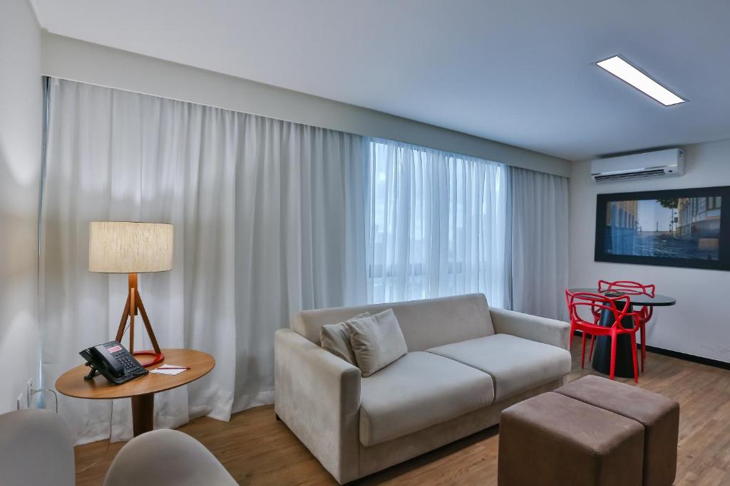 a living room with a couch and a table at Roomo Praia de Boa Viagem Residencial in Recife