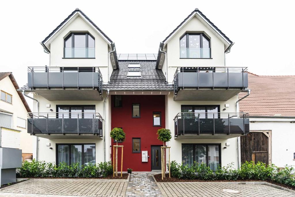 ein Haus mit einer roten Tür und einem Balkon in der Unterkunft Prim Loge in Balgheim