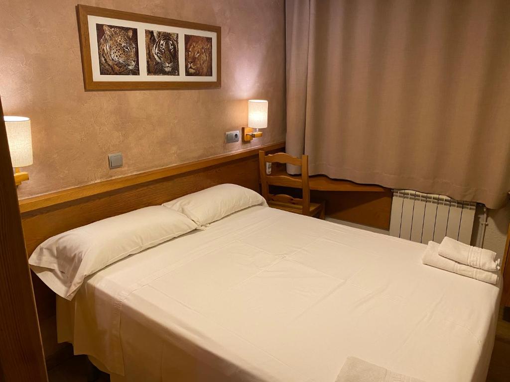 sypialnia z białym łóżkiem i oknem w obiekcie HOSTAL GALICIA CARDEDEU w mieście Cardedeu