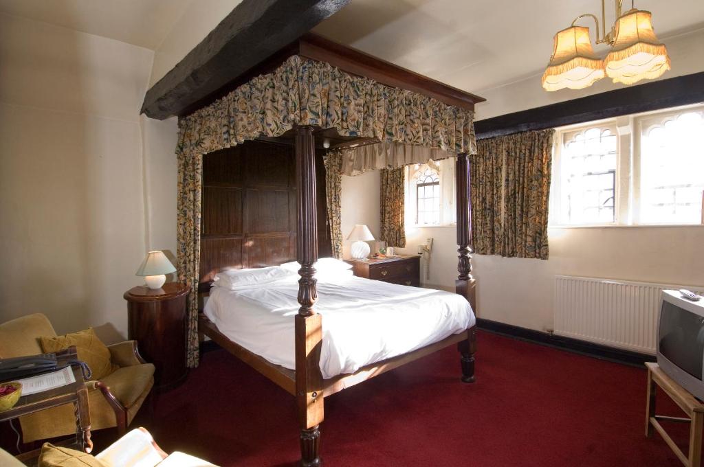 een slaapkamer met een hemelbed in een kamer bij George & Pilgrims Hotel in Glastonbury
