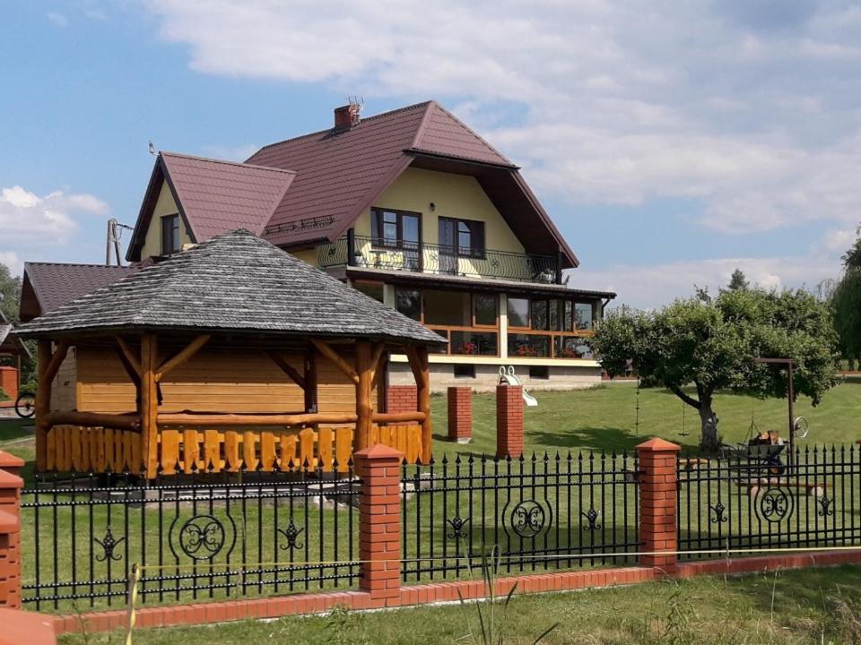 dom z altaną przed płotem w obiekcie Agroturystyka Żubrówka w mieście Żubrówka