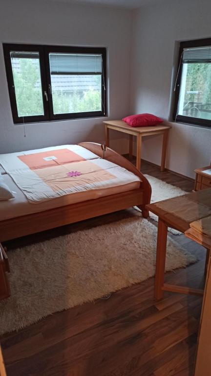 een slaapkamer met een groot bed en 2 ramen bij Kuca na selu sa bazenom in Štitar