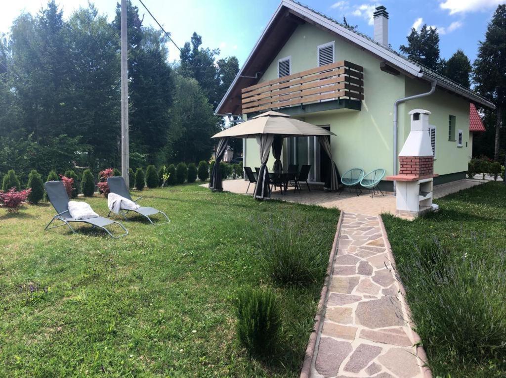 un cortile con due sedie e una casa di Holiday Home-kuća GORICA VERDE a Fužine