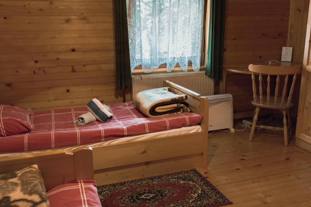 una camera con un letto e una sedia e una finestra di PENZIJON URBANC a Lovrenc na Pohorju