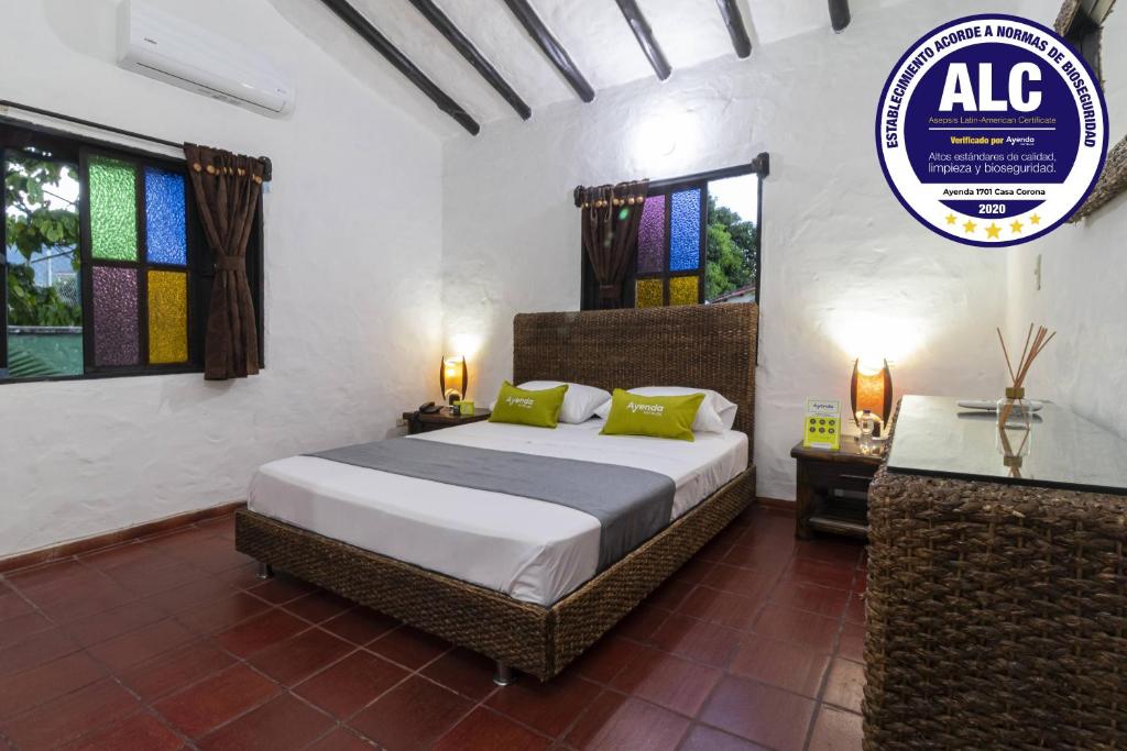 um quarto com uma cama e uma placa na parede em Ayenda Corona Real em Villavicencio