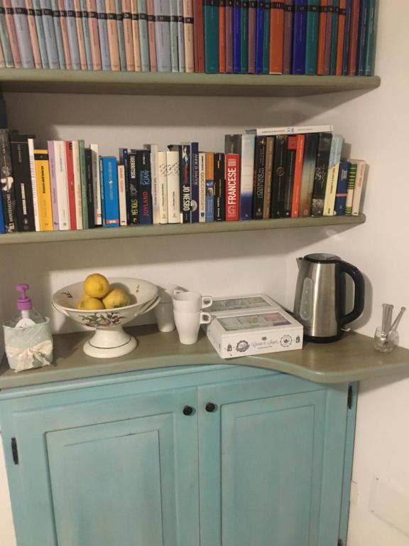 a blue cabinet with a bowl of fruit and books at B&B Il Tramonto in Castelsardo