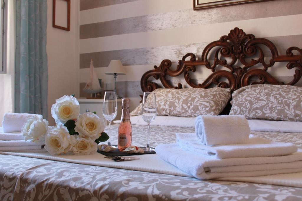 ラ・スペツィアにあるAffittacamere Perla del Prioneのベッド(タオル、ワイングラス、花付)