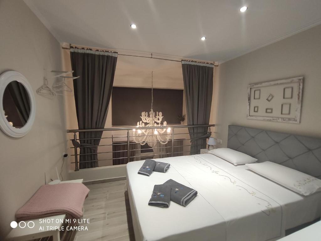 a bedroom with a large bed with two black shoes on it at Kamares suites in Nea Kallikrateia