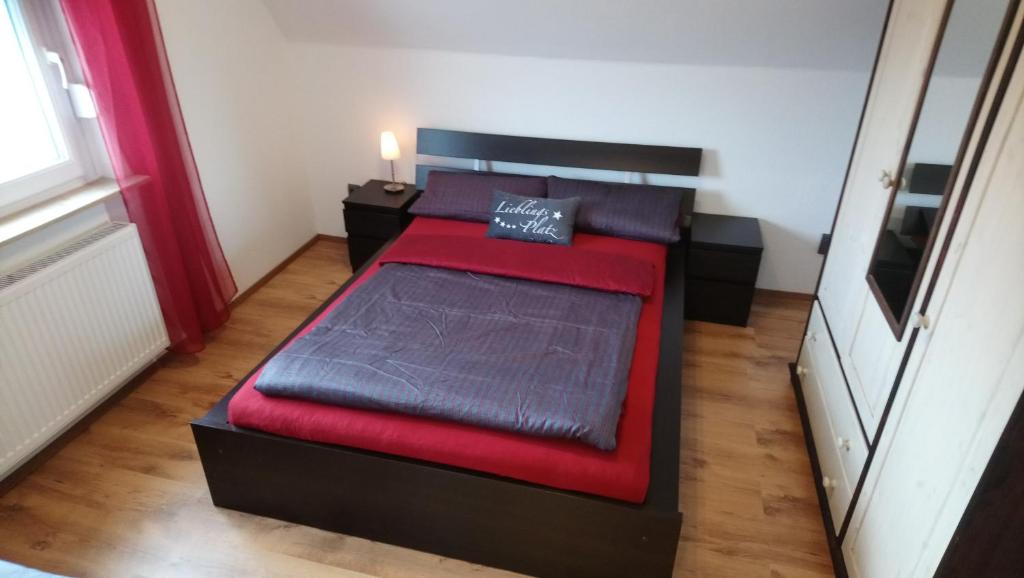Un dormitorio con una cama roja y negra en una habitación en Private Zimmer bei der Weser-Ems-Halle, en Oldenburg