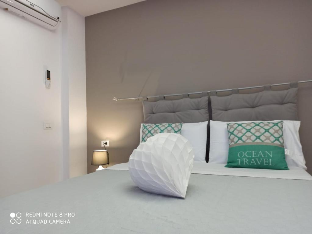 Dormitorio blanco con cama blanca y almohada verde en SOGNO D'ESTATE 2, en Mazara del Vallo