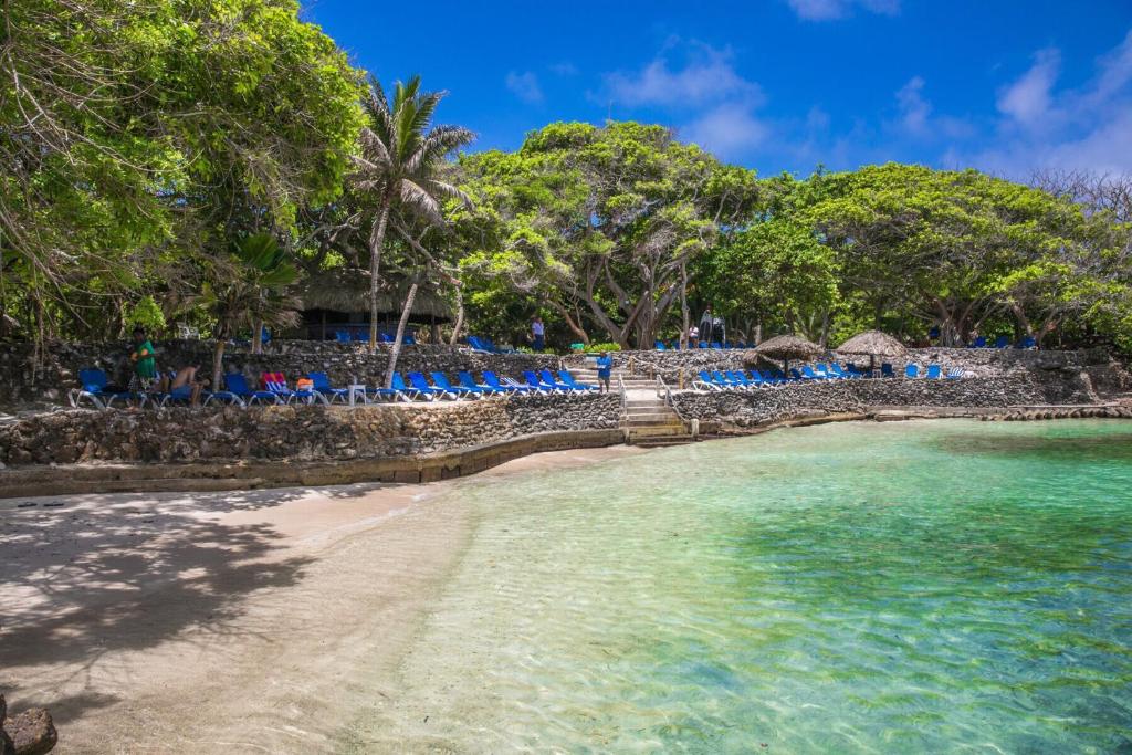 a beach with chairs and people in the water at Hotel San Pedro de Majagua in Isla Grande