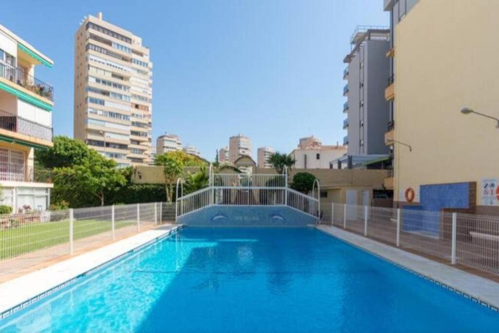 a large swimming pool in a city with buildings at Beach&Relax Torremolinos in Torremolinos
