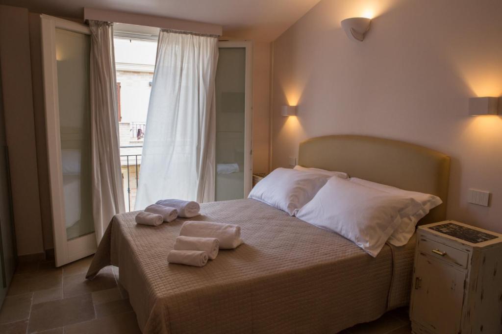 a bedroom with towels on a bed with a window at B&B Borgo Marinaro in Porto San Giorgio